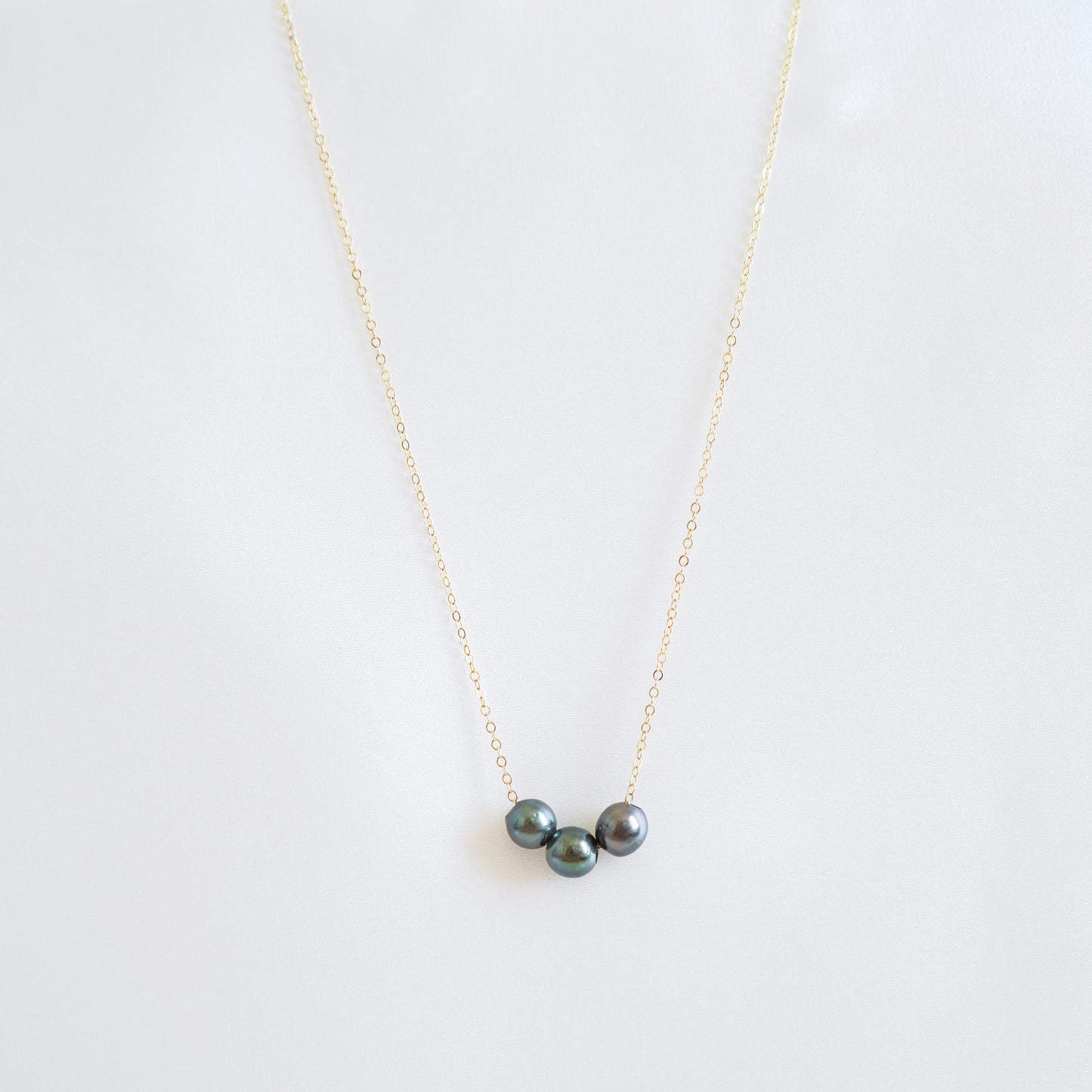 Necklace with three tahitian pearls on a white background
