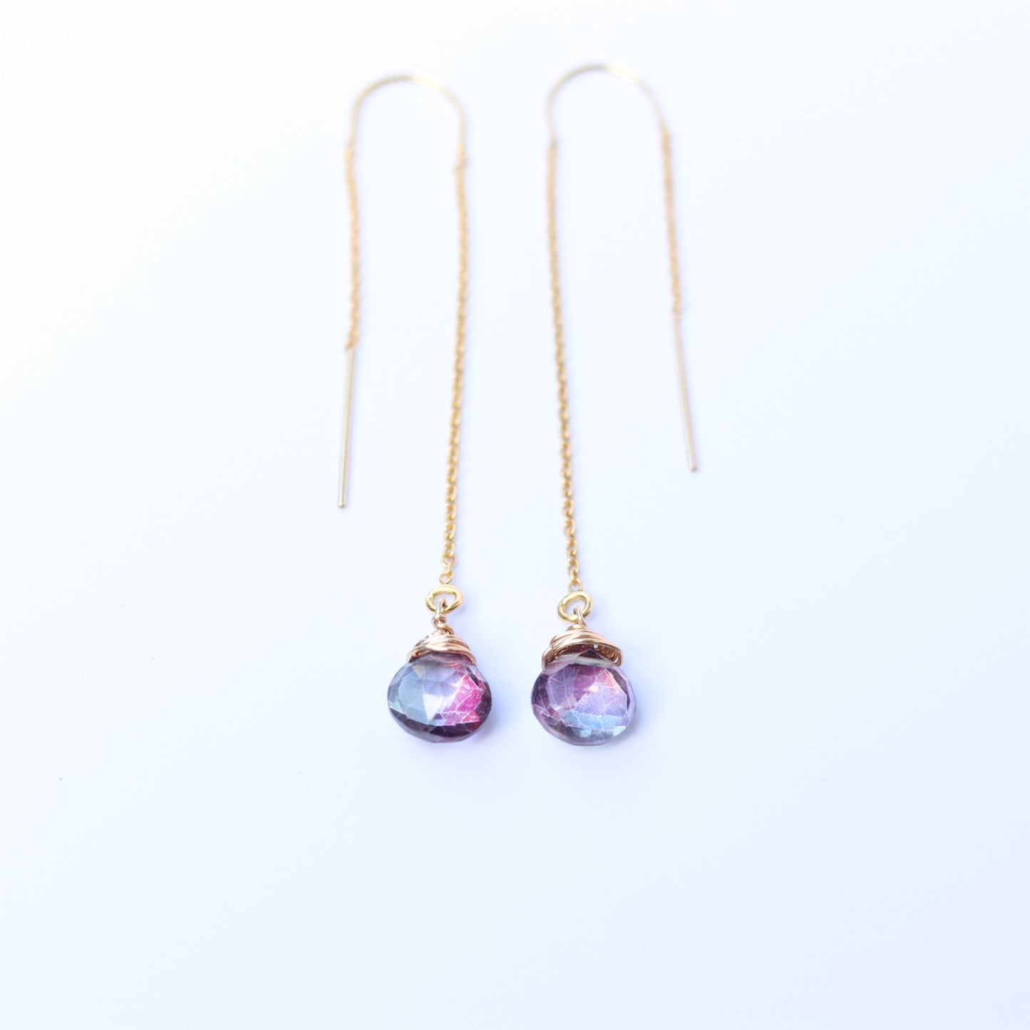Pair of earrings with gemstone drops on a white background