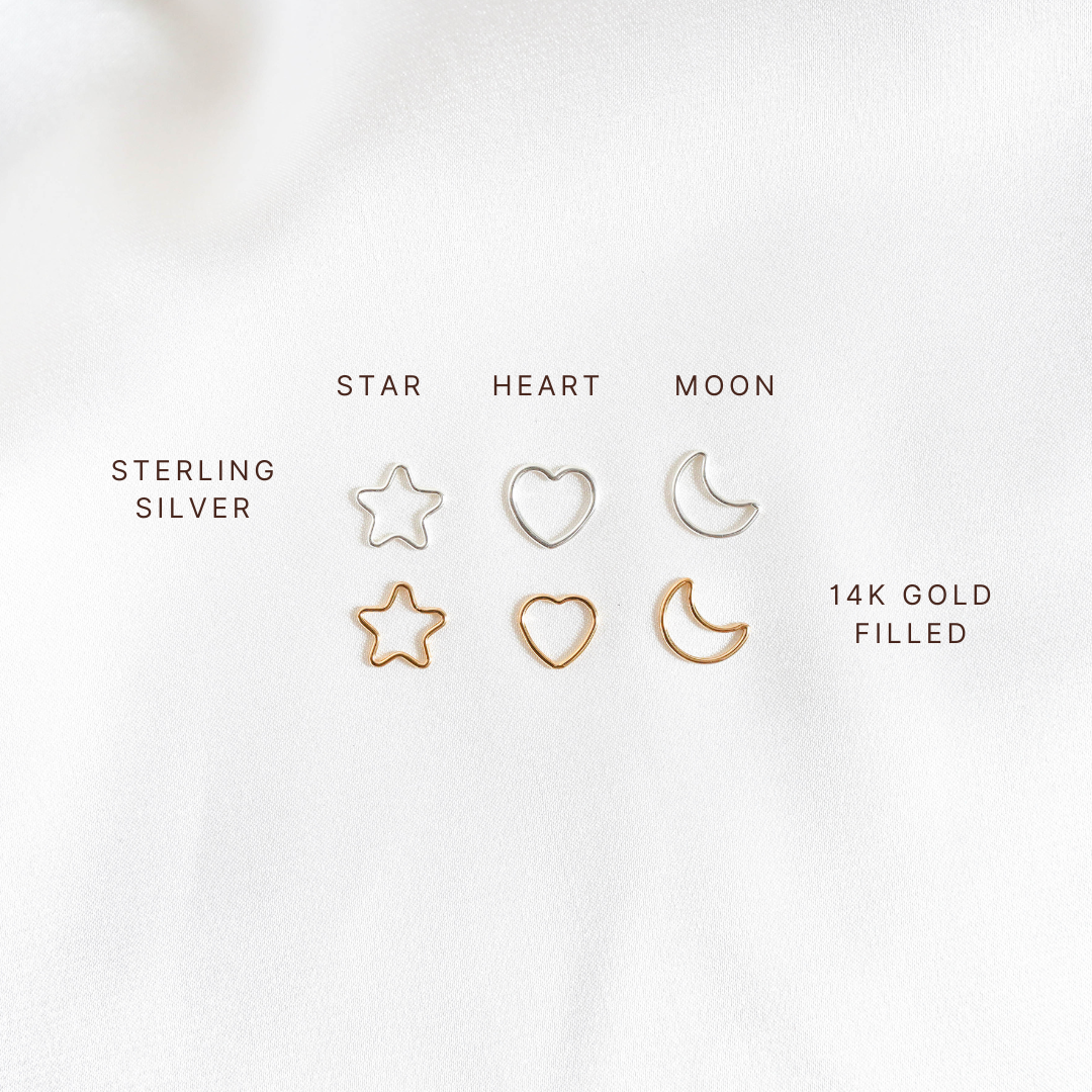 Set of star, heart, and moon-shaped charms in sterling silver and 14k gold filled on a white background.