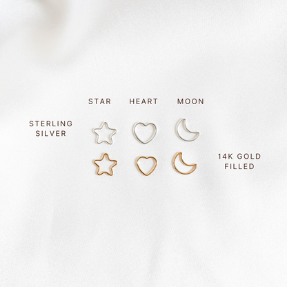 Set of star, heart, and moon-shaped charms in sterling silver and 14k gold filled on a white background.