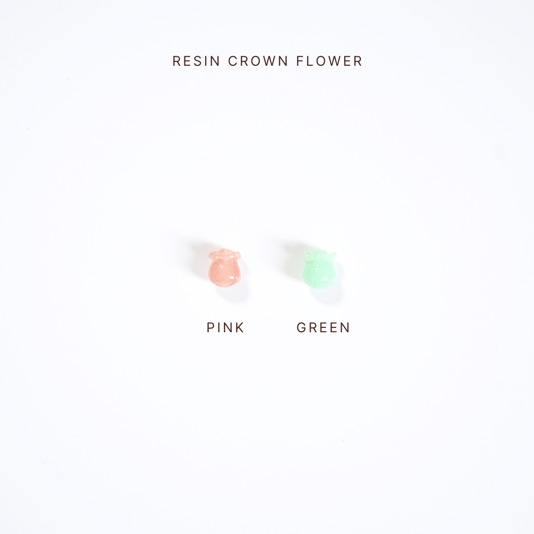 Two small resin crown flowers, one pink and one green, on a white background with text indicating color options.