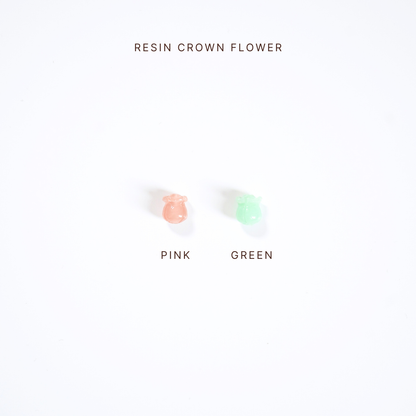 Two small resin crown flowers, one pink and one green, on a white background with text indicating color options.