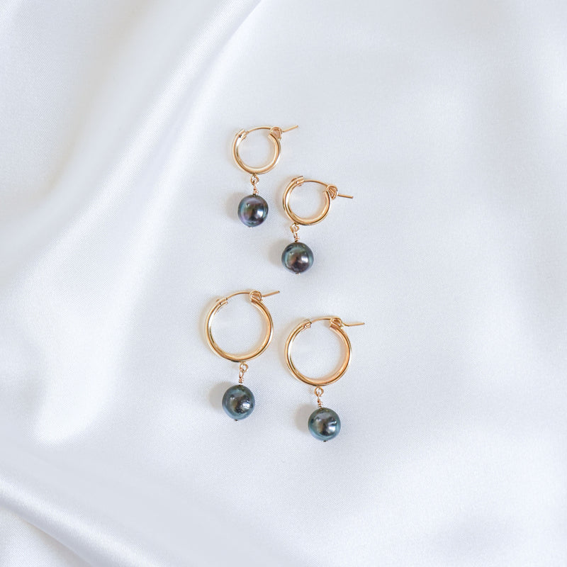 Two pairs of Gold hoop earrings with tahitian pearls on a white background