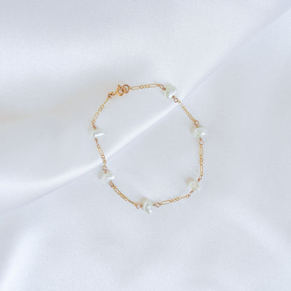 Gold bracelet with pearls on a white background