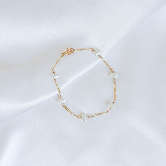 Gold bracelet with pearls on a white background