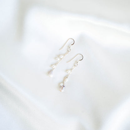 Pair of pearl and tiny cone shell dangle earrings on a white background
