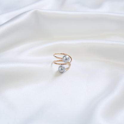 Gold ring with light blue pearls on a white fabric background