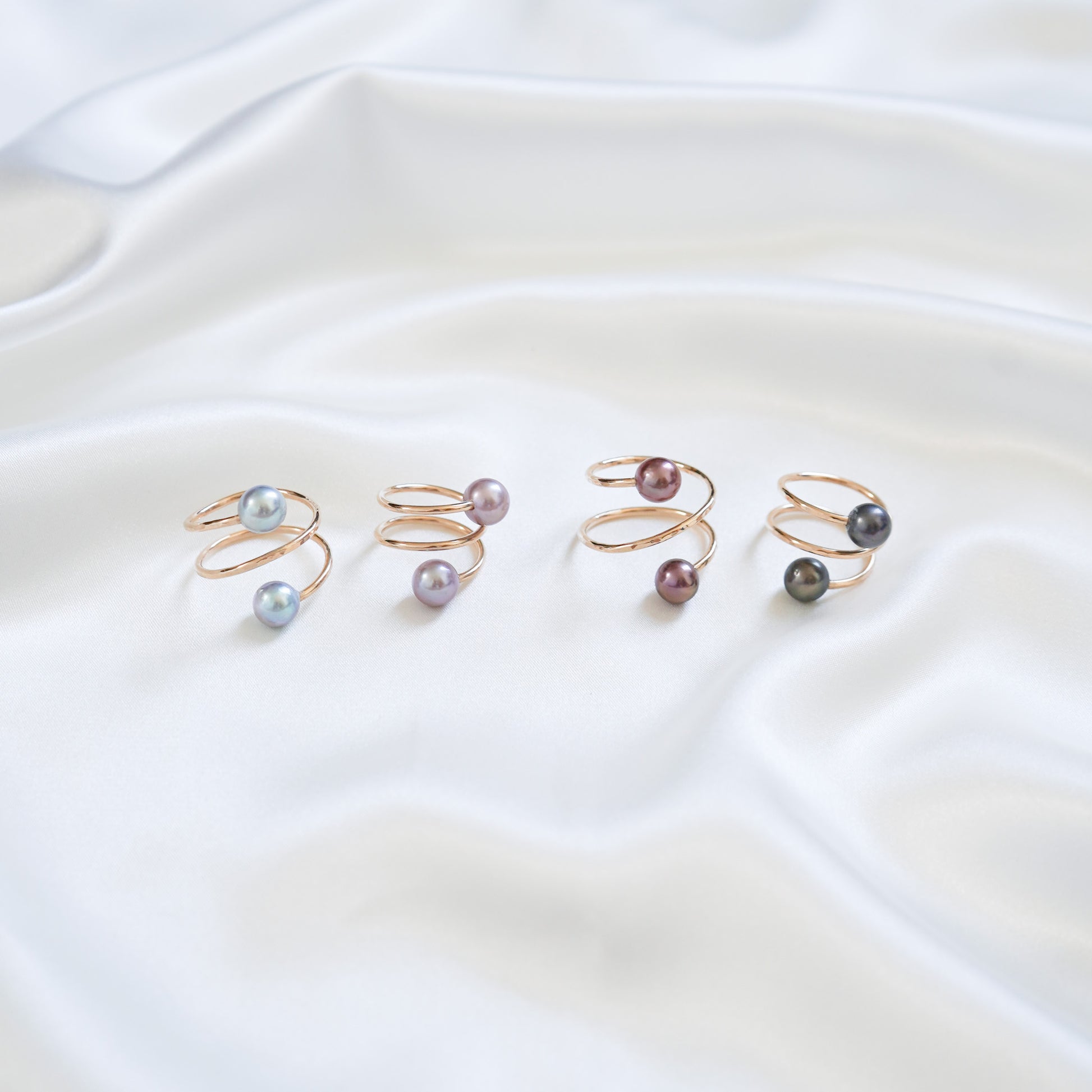 Set of pearl rings on a white fabric background