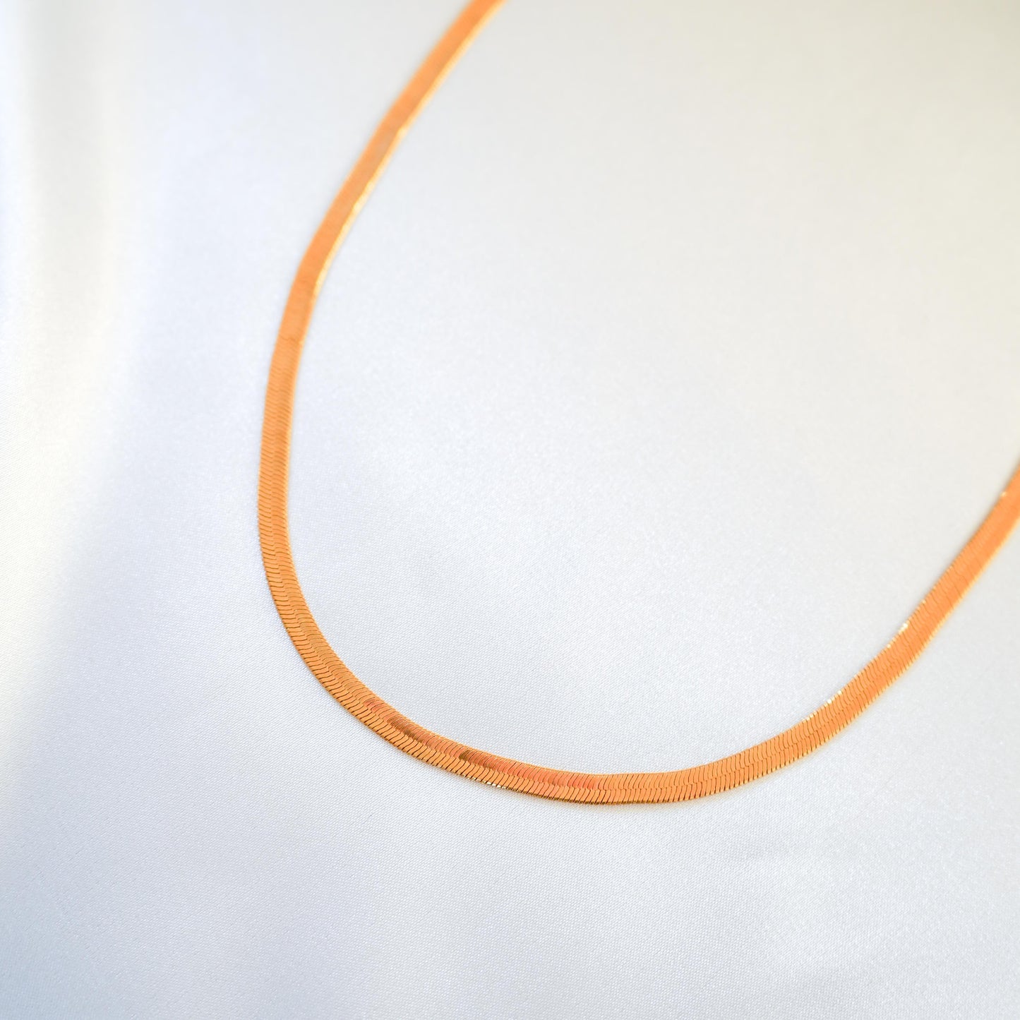 Close up of gold chain necklace on white background