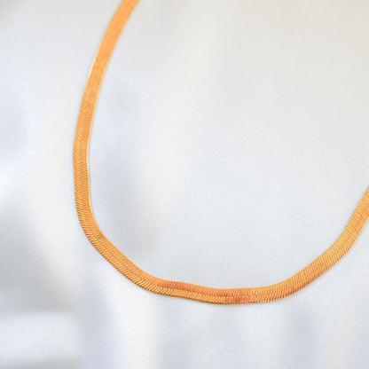 Close up of gold chain necklace on white background