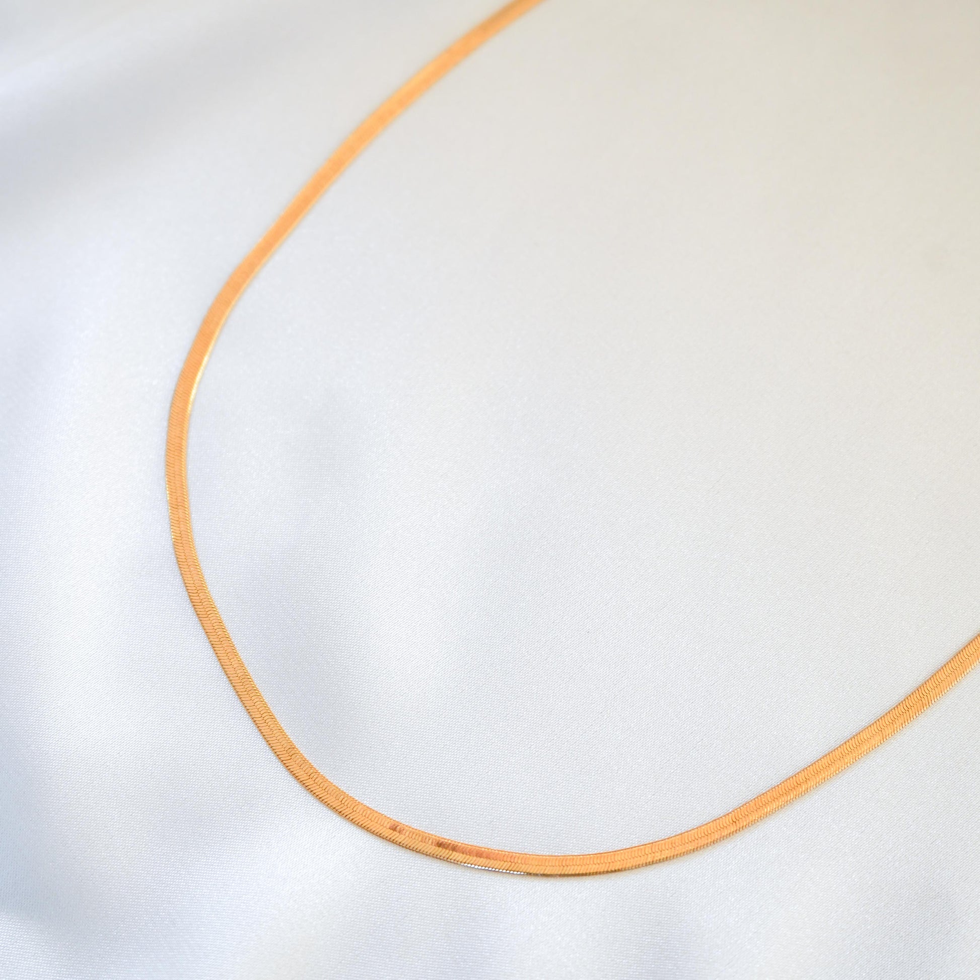 close up of gold chain on white background