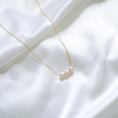 Close up of necklace with three white pearls