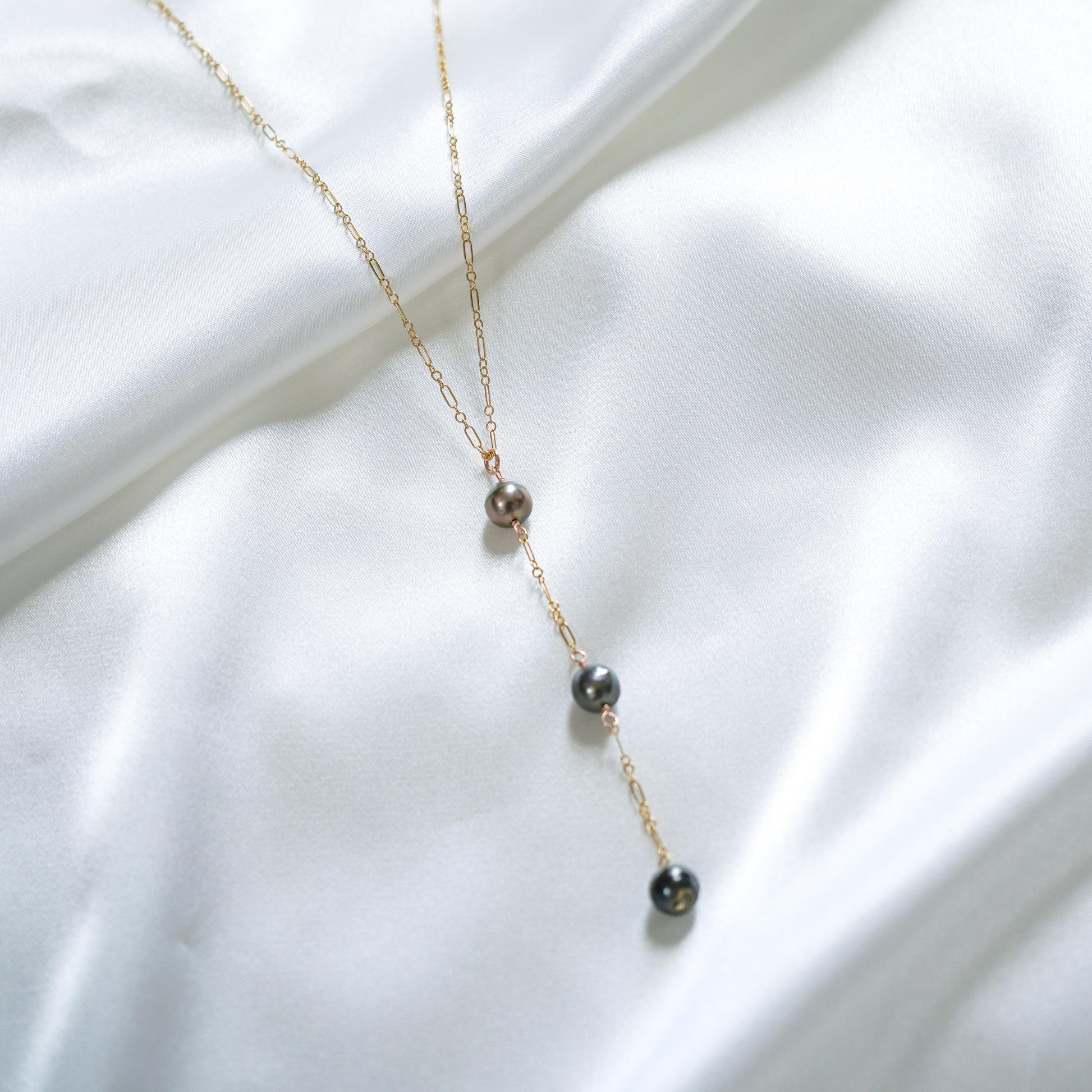 Gold necklace with three hanging pearl pendants 