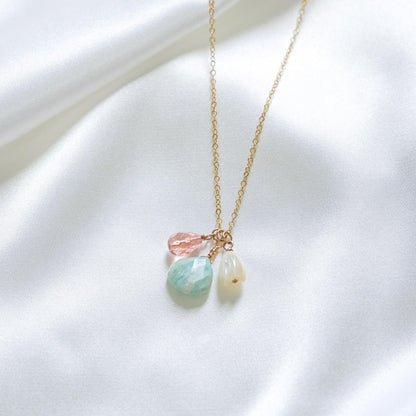 Necklace with pastel-colored beads and white pikake bead on a white background