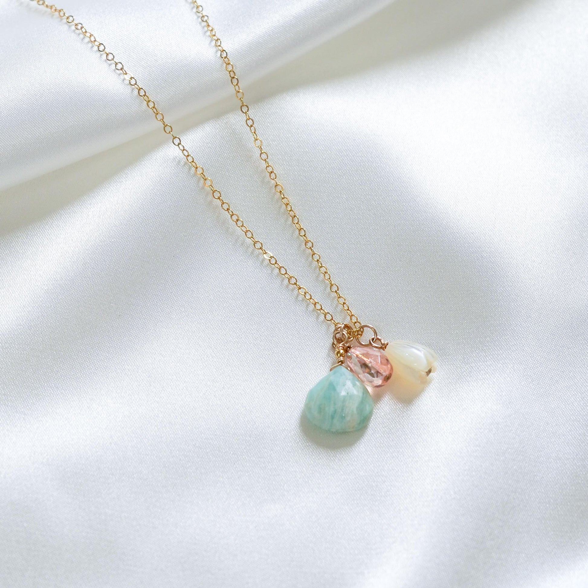 Necklace with pastel-colored beads and white pikake bead on a white background