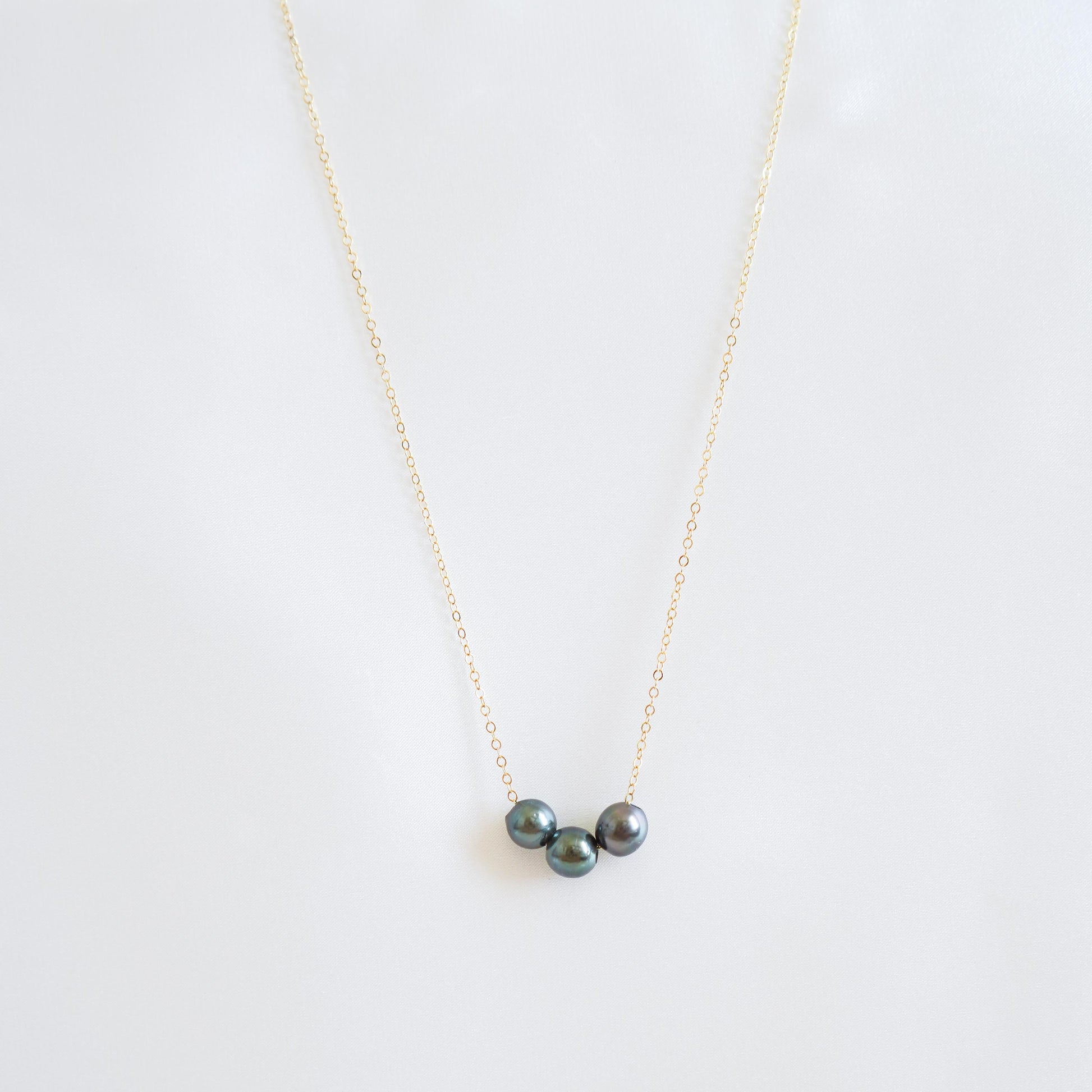 Necklace with three tahitian pearls on a white background
