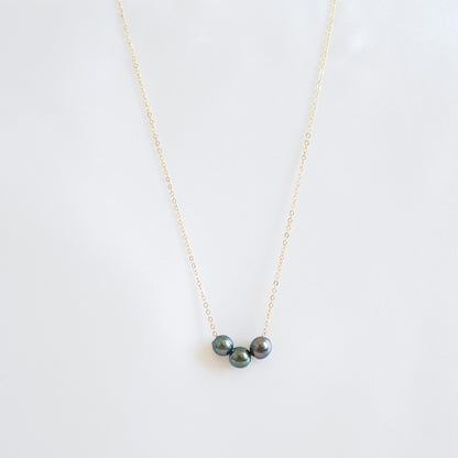 Necklace with three tahitian pearls on a white background