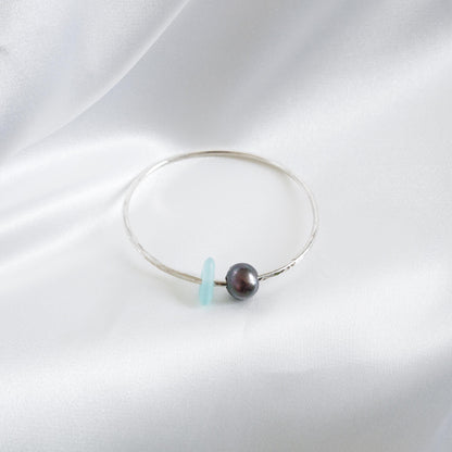 Bracelet with a tahitian pearl and blue sea glass on a white background