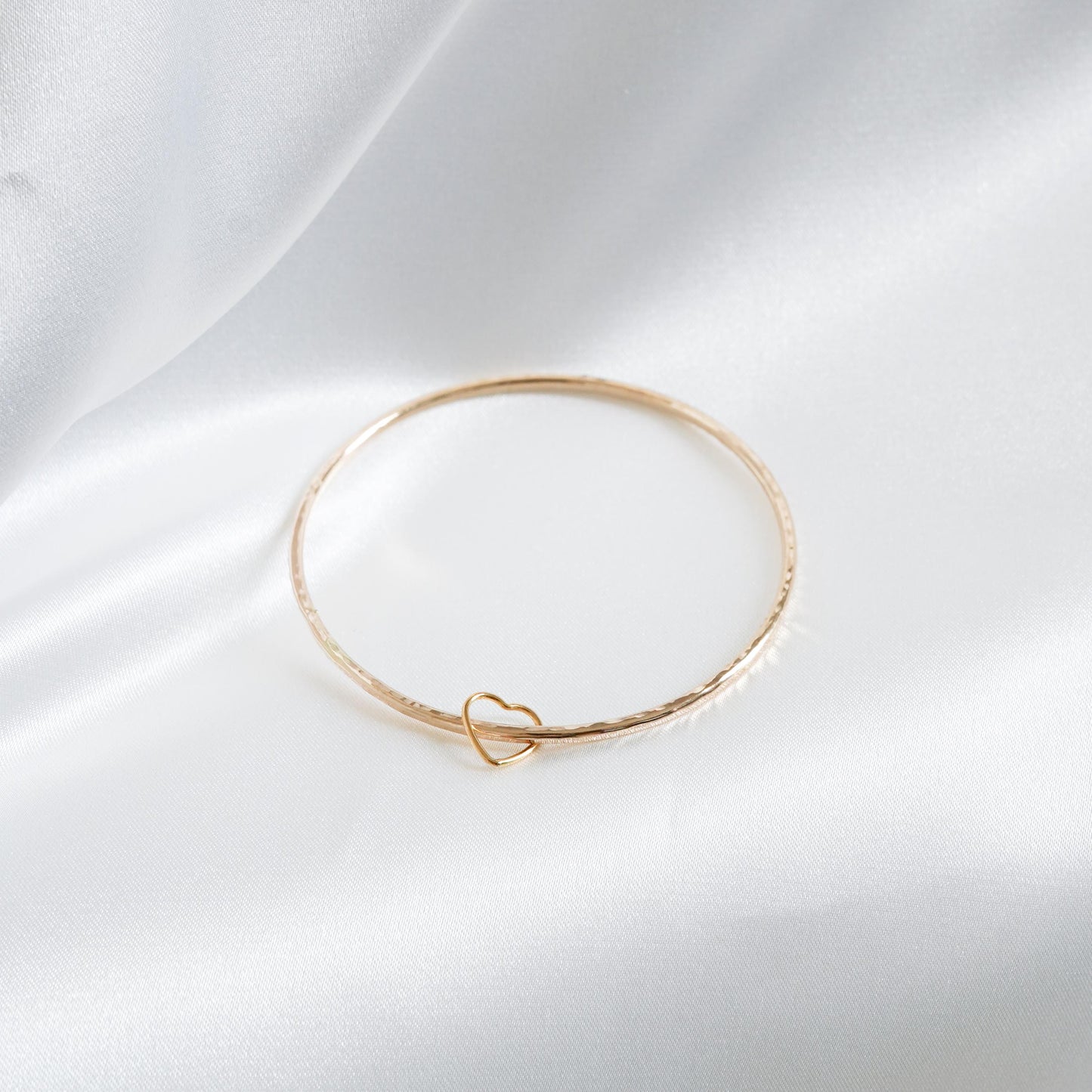 Simple gold bangle with heart charm