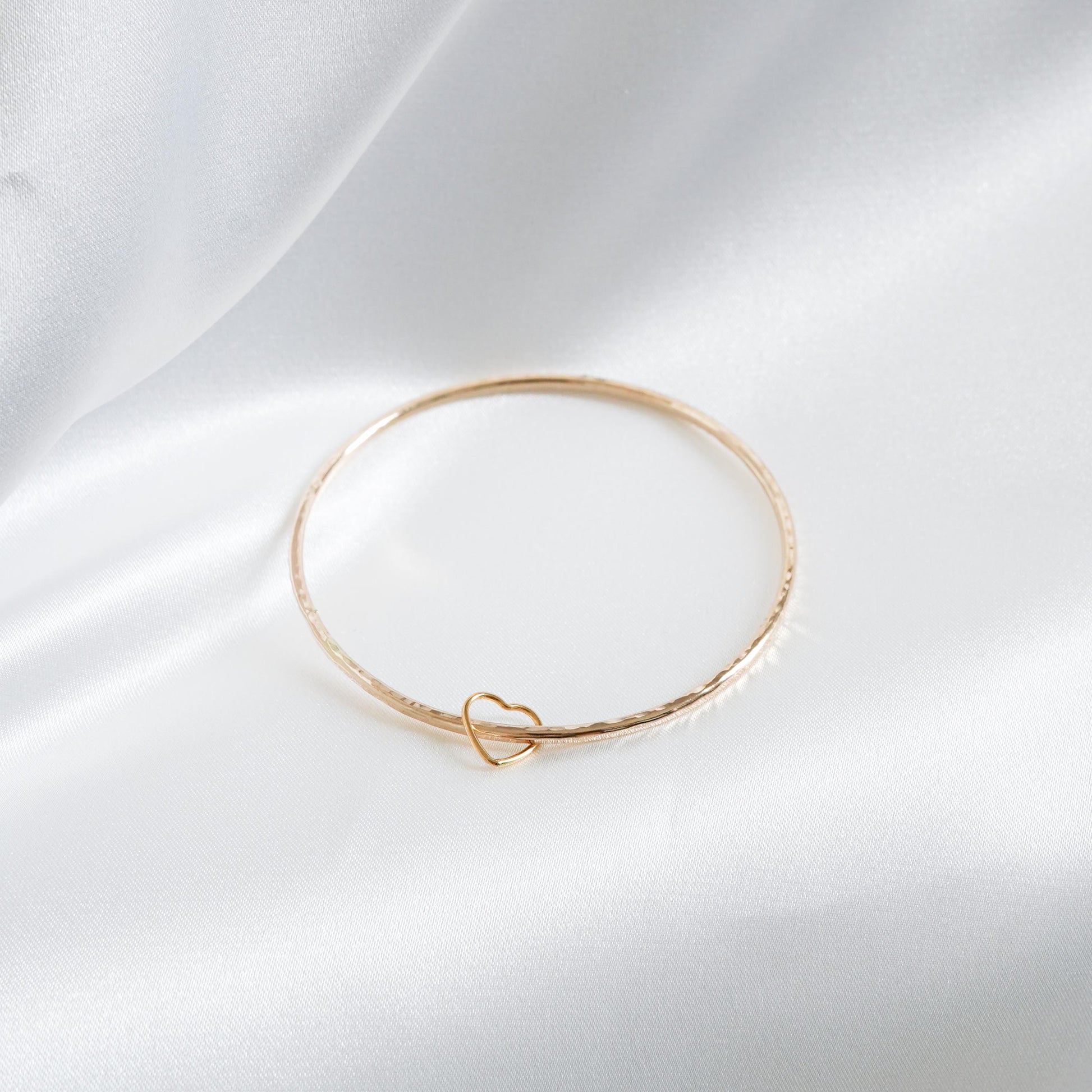 Simple gold bangle with heart charm
