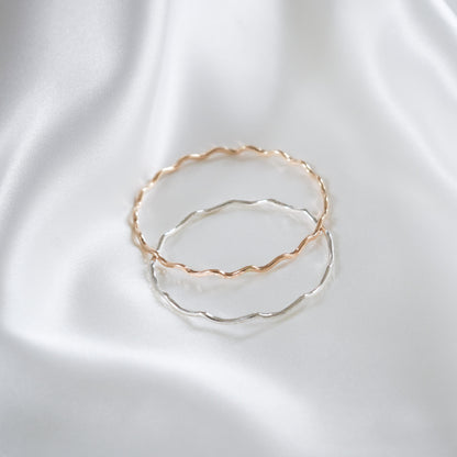 Gold and silver bangles on white satin background