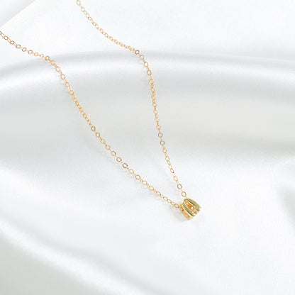 Gold necklace with a small A letter pendant on a white background