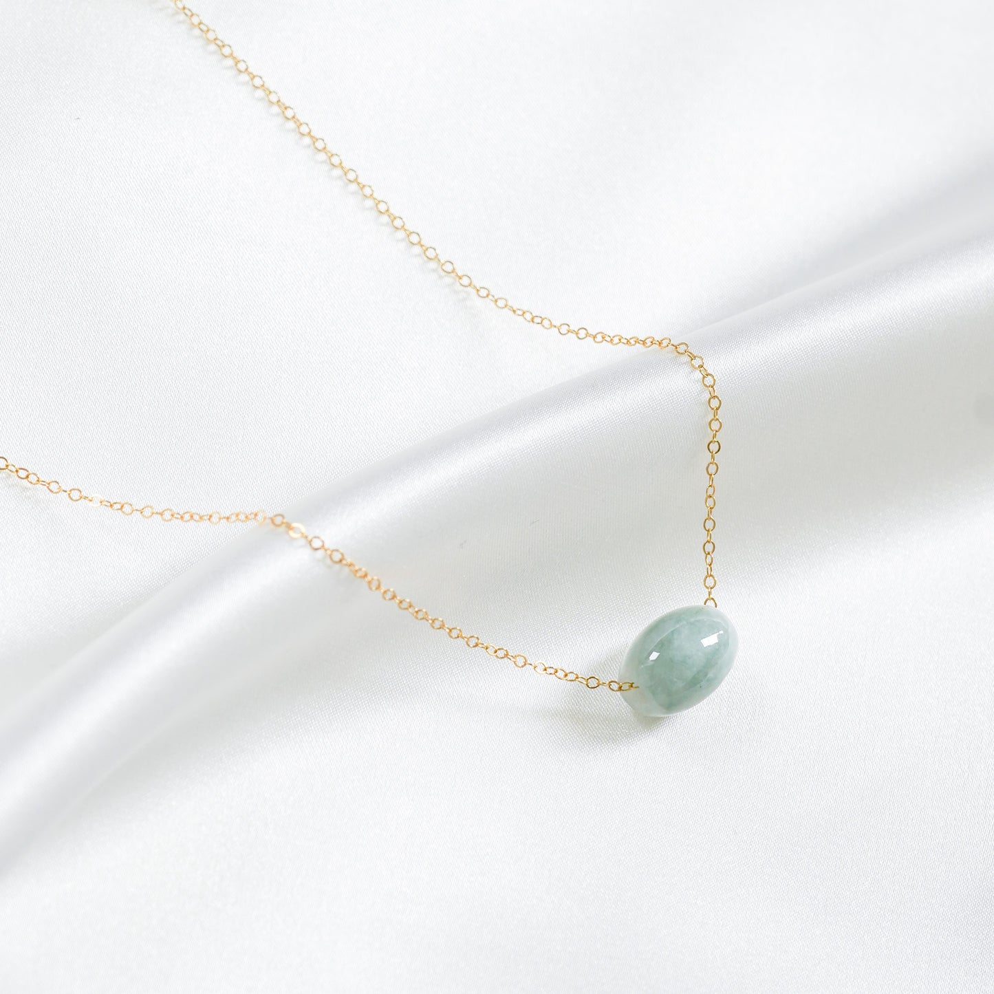 Necklace with a green jade pendant on a white background