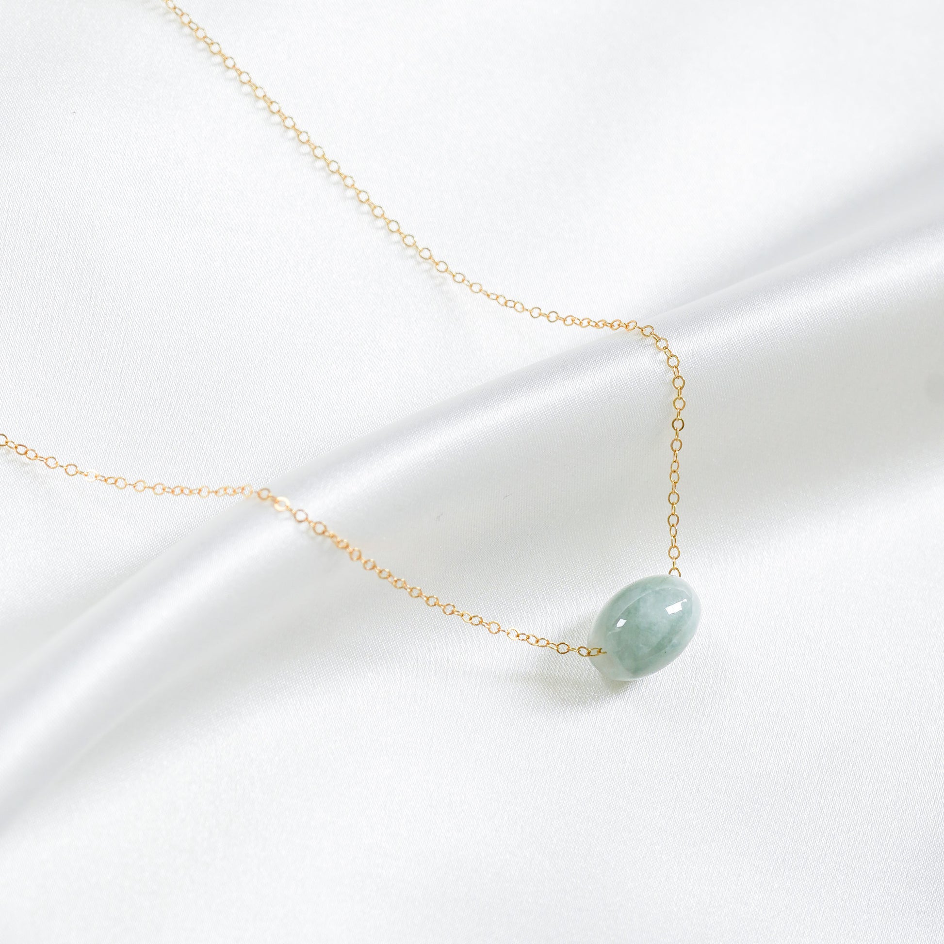 Necklace with a green jade pendant on a white background