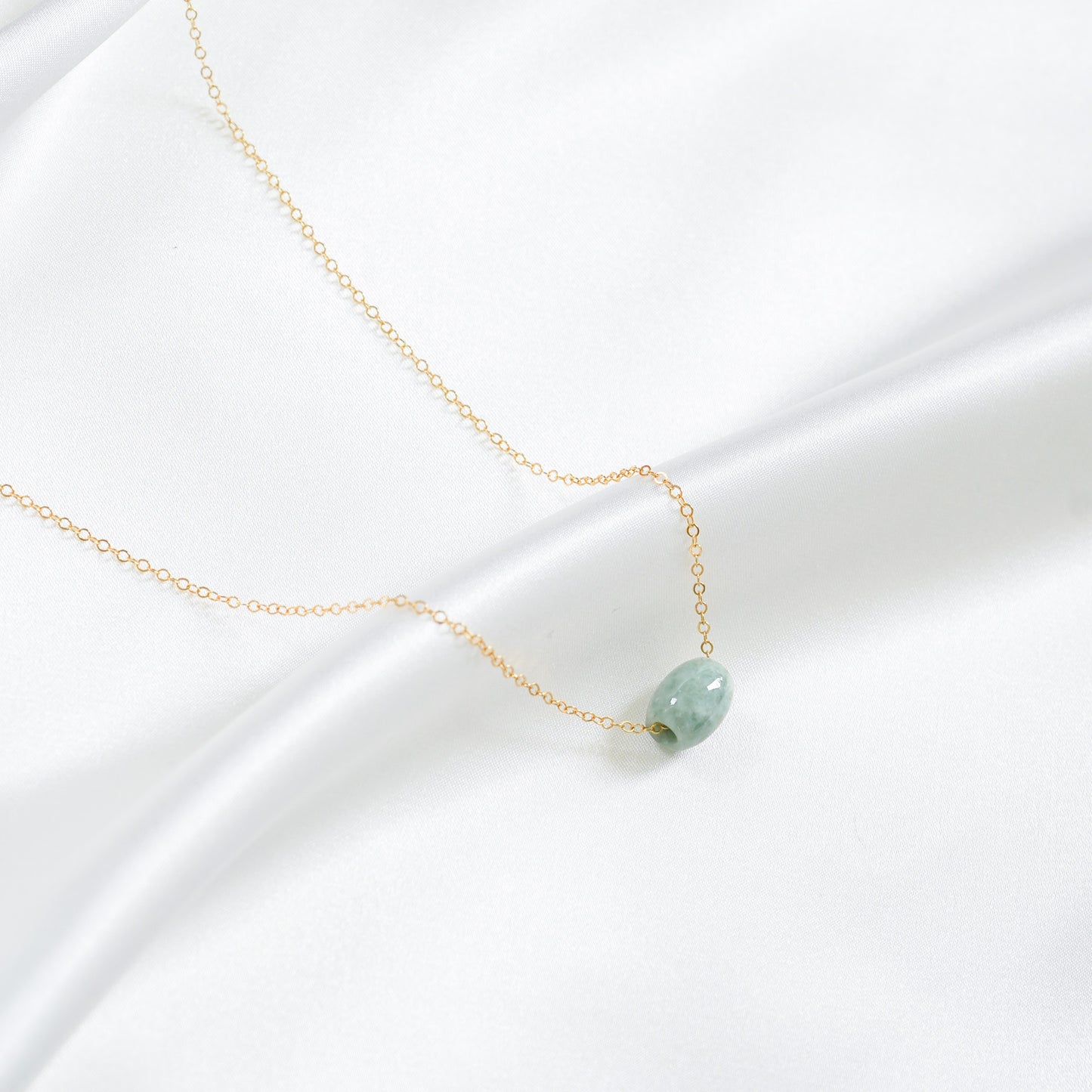 Necklace with a green jade on a white background