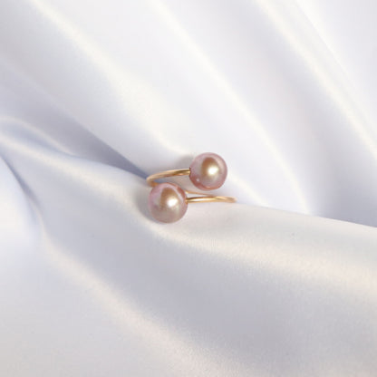 Ring with two pink pearls on a soft white fabric background