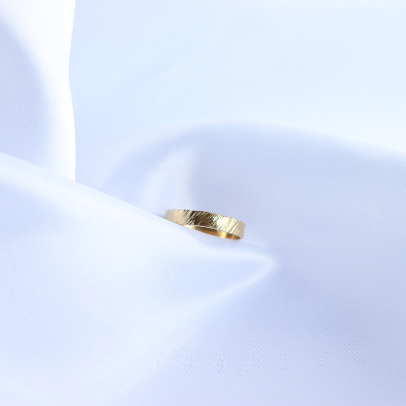 Thick gold ring on a white fabric background