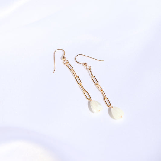 Gold paperclip chain earrings with a single pikake bead on a white background
