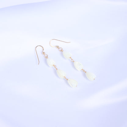 Pair of gold earrings with white pikake flower beads on a white background