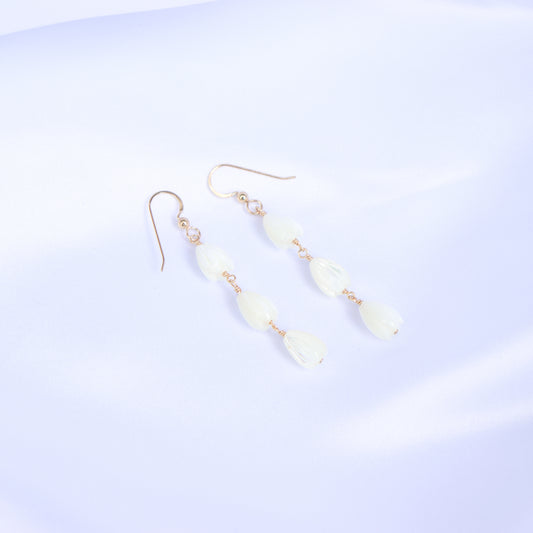 Pair of gold earrings with white pikake flower beads on a white background